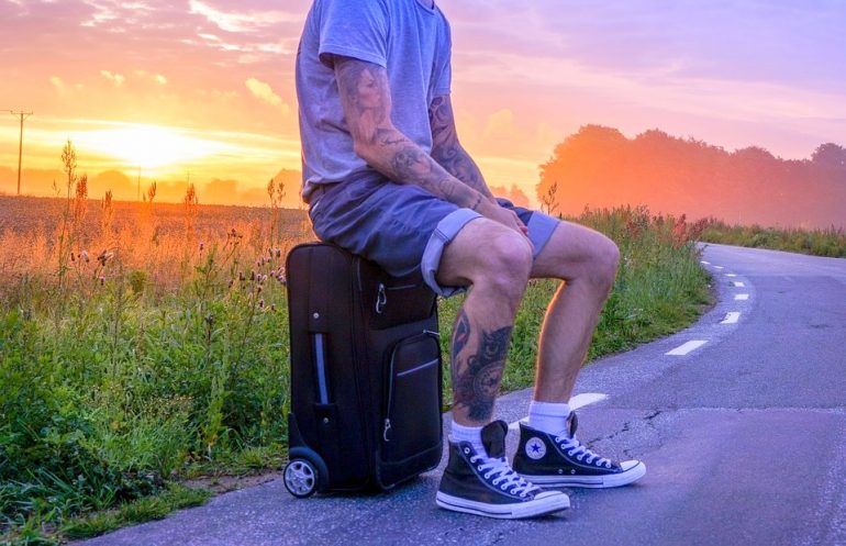 A man seating on a suitcase